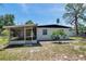 Exterior view of the home showcasing its backyard, screened-in patio, and well-maintained landscaping at 6507 La Mesa Cir, Tampa, FL 33634