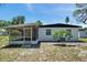 Home exterior featuring a screened-in patio, a small tree, and a brick exterior finish at 6507 La Mesa Cir, Tampa, FL 33634