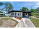 Charming single-story home featuring a covered carport, fresh landscaping, and a gated front yard at 6507 La Mesa Cir, Tampa, FL 33634