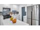 Modern kitchen with stainless steel appliances, white cabinets, and a gray backsplash offers a clean, stylish look at 6507 La Mesa Cir, Tampa, FL 33634