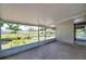 Enclosed patio with screen windows and concrete floor, offering an outdoor space with views of the backyard at 6507 La Mesa Cir, Tampa, FL 33634