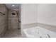 Bathroom with a tiled walk-in shower and a luxurious soaking tub at 6521 Oelsner St, New Port Richey, FL 34652