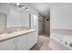 Bright bathroom featuring dual sinks, a separate shower, and a luxurious soaking tub for relaxation at 6521 Oelsner St, New Port Richey, FL 34652