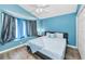 Cozy bedroom with a window seat, soft blue accents, and wood-look floors at 6521 Oelsner St, New Port Richey, FL 34652