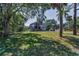 Two-story home with large lawn, framed by mature trees and lush landscaping at 6521 Oelsner St, New Port Richey, FL 34652