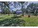 Exterior view of home with large yard, fenced area, and mature landscaping at 6521 Oelsner St, New Port Richey, FL 34652