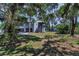 Exterior of home shaded by mature trees, featuring a covered stairway and attached garage at 6521 Oelsner St, New Port Richey, FL 34652
