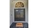 Close-up of the stately black double front doors with a transom window and a welcoming door mat at 6521 Oelsner St, New Port Richey, FL 34652