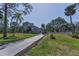 Two-story home features a long driveway and a well-manicured lawn with mature trees at 6521 Oelsner St, New Port Richey, FL 34652