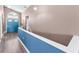 Hallway with wood floors and contrasting blue accent wall leading towards the home's entryway at 6521 Oelsner St, New Port Richey, FL 34652