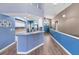 Open-concept kitchen area with a view of the entryway, featuring blue walls and modern countertops at 6521 Oelsner St, New Port Richey, FL 34652