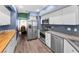 Modern kitchen features stainless steel appliances, white cabinets, and laminate wood flooring at 6521 Oelsner St, New Port Richey, FL 34652