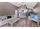 Open-concept living room with wood floors and views of the kitchen and entry, great for modern living at 6521 Oelsner St, New Port Richey, FL 34652