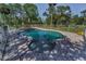 Inviting backyard pool enclosed by a white fence, surrounded by a brick patio at 6521 Oelsner St, New Port Richey, FL 34652