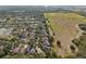 Aerial view showing a neighborhood backing up to a large grassy field at 6914 Monarch Park Dr, Apollo Beach, FL 33572