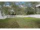 This fenced backyard features mature trees and green grass at 6914 Monarch Park Dr, Apollo Beach, FL 33572