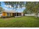 An expansive yard with lush green grass, white picket fence and a screened lanai attached to the house at 6914 Monarch Park Dr, Apollo Beach, FL 33572