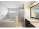 Bathroom featuring a large tub, separate shower, and dark vanity with light countertop, offering a clean and elegant look at 6914 Monarch Park Dr, Apollo Beach, FL 33572