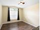 This bedroom has dark laminate flooring and a window for plenty of natural light at 6914 Monarch Park Dr, Apollo Beach, FL 33572