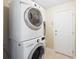 This laundry room includes tile flooring and stackable washer and dryer at 6914 Monarch Park Dr, Apollo Beach, FL 33572