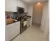 Galley kitchen features stainless steel appliances and white cabinets at 804 67Th W St, Bradenton, FL 34209