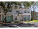Inviting townhome with a well-manicured lawn, reserved parking, and pretty pastel-colored doors and shutters at 8545 Hunters Key Cir, Tampa, FL 33647
