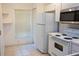 Bright kitchen featuring tiled flooring, white appliances, and ample cabinet space at 8545 Hunters Key Cir, Tampa, FL 33647
