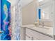 Bathroom showcasing granite countertops, white cabinets, and a mermaid shower curtain at 8921 Blind Pass Rd # 142, St Pete Beach, FL 33706