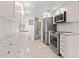 Bright kitchen with modern appliances, light wood flooring, and a view of the bathroom at 8921 Blind Pass Rd # 142, St Pete Beach, FL 33706
