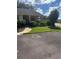 Landscaped front yard with mature bushes, green grass, and a view of the villa at 9302 Trowbridge Ct, New Port Richey, FL 34655