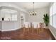 Bright dining room showcasing wood floors, natural light and modern chandelier, virtually staged with modern furniture at 9329 Huntington Park Way, Tampa, FL 33647