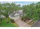 Aerial view of a one story home with large trees and green lawn at 9329 Huntington Park Way, Tampa, FL 33647