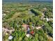 An aerial view shows the home surrounded by lush green trees, bushes and a small pond at 9690 Jerome Dr, New Port Richey, FL 34654