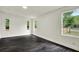 Spacious room with natural light, with dark wood floors and neutral walls at 9690 Jerome Dr, New Port Richey, FL 34654