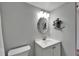 Bathroom with a white vanity, sink, nautical decorations, and a round mirror at 1028 Apollo Beach Blvd # 21, Apollo Beach, FL 33572