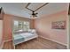 Cozy bedroom with a ceiling fan, window with shutters, and light wood-look flooring at 1028 Apollo Beach Blvd # 21, Apollo Beach, FL 33572