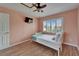Inviting bedroom with a ceiling fan, window with shutters, and mounted TV at 1028 Apollo Beach Blvd # 21, Apollo Beach, FL 33572