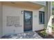 Close-up of the main entrance with a decorative seashell ornament and view of the tile patio at 1028 Apollo Beach Blvd # 21, Apollo Beach, FL 33572