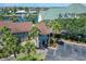 Waterfront condo exterior featuring lush tropical landscaping, assigned parking, and serene water views at 1028 Apollo Beach Blvd # 21, Apollo Beach, FL 33572