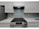 Close-up of the kitchen range with modern backsplash and countertops at 1028 Apollo Beach Blvd # 21, Apollo Beach, FL 33572