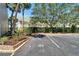 View of a parking area next to a colorful building with a landscaped area and palm trees at 1028 Apollo Beach Blvd # 21, Apollo Beach, FL 33572