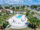Aerial view of a community pool featuring lounge chairs and umbrellas surrounded by mature palm trees at 1028 Apollo Beach Blvd # 21, Apollo Beach, FL 33572