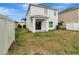 Exterior elevation showing a white two-story home and fenced backyard with sliding glass doors at 1107 Seminole Sky Dr, Ruskin, FL 33570