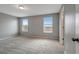 A spacious bedroom with neutral walls, plush carpet, and natural light from two windows at 1107 Seminole Sky Dr, Ruskin, FL 33570