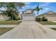 Two-story home with a two-car garage, a well-maintained lawn, and a palm tree at 1107 Seminole Sky Dr, Ruskin, FL 33570