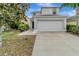 Two-story home with a two-car garage, landscaping, and a sidewalk at 1107 Seminole Sky Dr, Ruskin, FL 33570