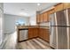 Well-lit kitchen with wood cabinets, granite countertops, and stainless steel appliances at 1107 Seminole Sky Dr, Ruskin, FL 33570