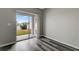 Spacious room featuring wood-look flooring and a sliding glass door to the patio at 1107 Seminole Sky Dr, Ruskin, FL 33570