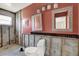 Unfinished bathroom with tile mirrors, new toilet, and peach walls at 11628 Grove St, Seminole, FL 33772