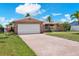 Charming single-story home featuring a brick facade, a wide driveway, and a two-car garage at 11628 Grove St, Seminole, FL 33772